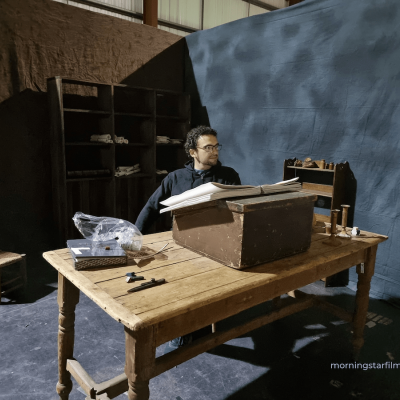 During set up, Murdo takes a rest at Wycliffe's desk